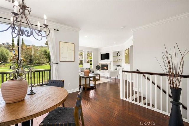 10108 Marchant Ave, Tustin, CA 92782 - dining room with a chandelier, hardwood / wood-style flooring, a warm lit fireplace, ornamental molding, and built in shelves