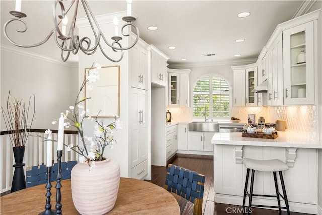 10108 Marchant Ave, Tustin, CA 92782 - kitchen featuring a sink, light countertops, a peninsula, crown molding, and dark wood-type flooring