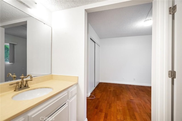 10149 Commerce Ave Unit 8, Tujunga, CA 91042 - bathroom with a textured ceiling, wood finished floors, vanity, and baseboards