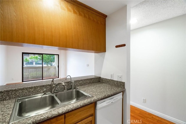 10149 Commerce Ave Unit 8, Tujunga, CA 91042 - kitchen featuring white dishwasher, a sink, brown cabinets, light wood-style flooring, and dark countertops