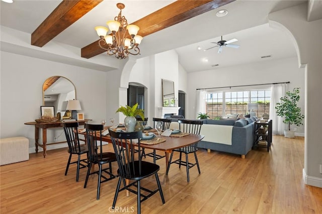 35 Veneto Cir, Chico, CA 95926 - dining area with arched walkways, a fireplace, light wood-style flooring, a chandelier, and beamed ceiling