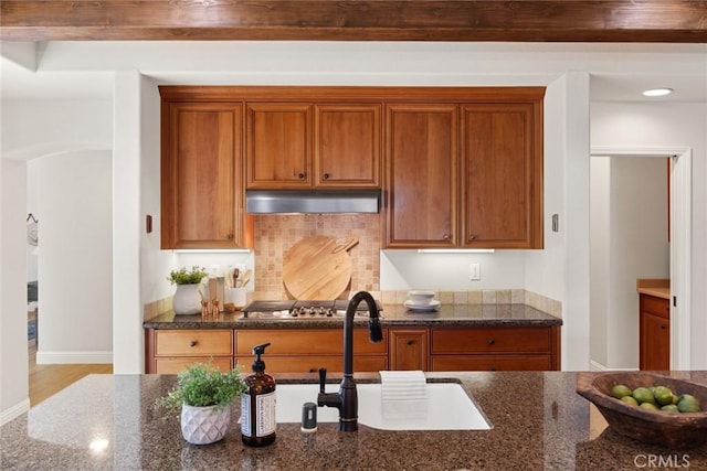 35 Veneto Cir, Chico, CA 95926 - kitchen with a sink, under cabinet range hood, stainless steel gas stovetop, dark stone counters, and brown cabinets
