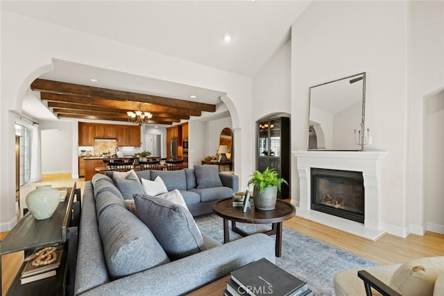 35 Veneto Cir, Chico, CA 95926 - living room featuring arched walkways, a chandelier, light wood-type flooring, beamed ceiling, and recessed lighting