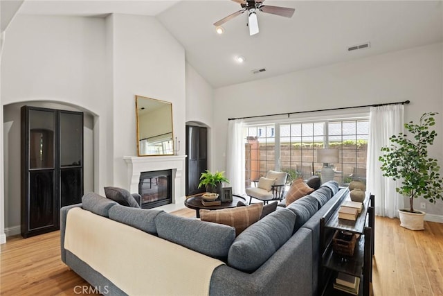 35 Veneto Cir, Chico, CA 95926 - living room featuring high vaulted ceiling, a glass covered fireplace, ceiling fan, baseboards, and light wood-type flooring