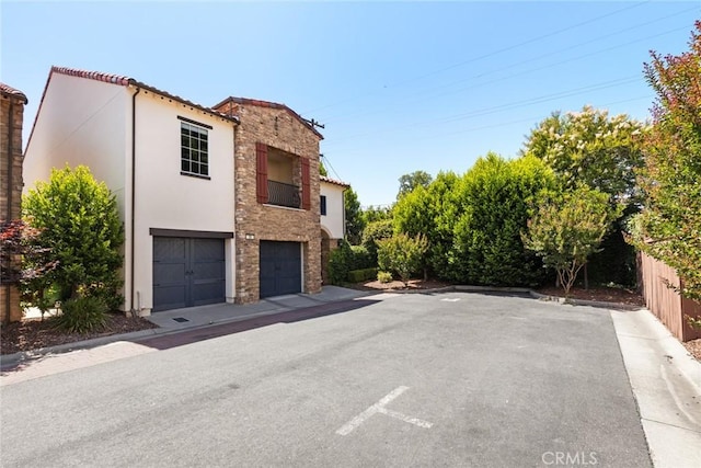35 Veneto Cir, Chico, CA 95926 - view of side of home with stucco siding, stone siding, and a garage