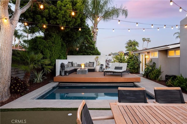 292 Bowling Green Dr, Costa Mesa, CA 92626 - pool at dusk featuring an outdoor living space with a fire pit, a patio area, a deck, and outdoor dining space