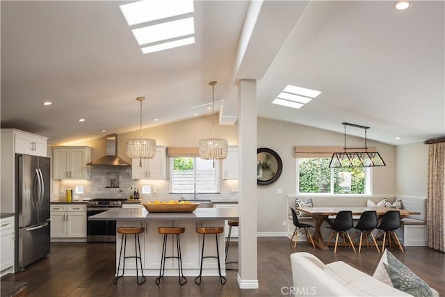 292 Bowling Green Dr, Costa Mesa, CA 92626 - kitchen with appliances with stainless steel finishes, wall chimney range hood, vaulted ceiling, tasteful backsplash, and white cabinets