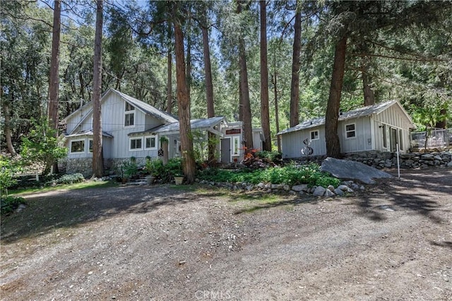 9091 Mountain View Dr, Forest Falls, CA 92339 - view of front of house featuring board and batten siding, stone siding, and an outbuilding
