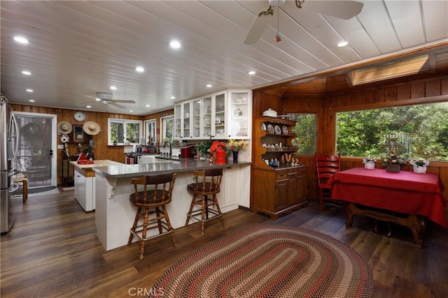 9091 Mountain View Dr, Forest Falls, CA 92339 - kitchen featuring ceiling fan, wood walls, a peninsula, glass insert cabinets, and recessed lighting