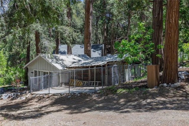 9091 Mountain View Dr, Forest Falls, CA 92339 - view of front of home featuring dirt driveway, board and batten siding, metal roof, and a wooded view