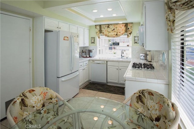 11 Jasmine Creek Ln, Laguna Hills, CA 92653 - kitchen featuring white appliances, tile countertops, backsplash, a raised ceiling, and white cabinets