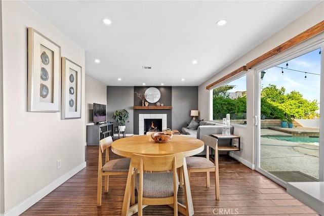 18534 Dylan St, Porter Ranch, CA 91326 - dining area featuring recessed lighting, a tiled fireplace, baseboards, and wood finished floors
