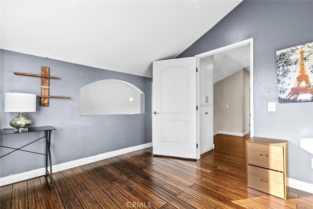 18534 Dylan St, Porter Ranch, CA 91326 - empty room featuring vaulted ceiling, wood finished floors, arched walkways, and baseboards