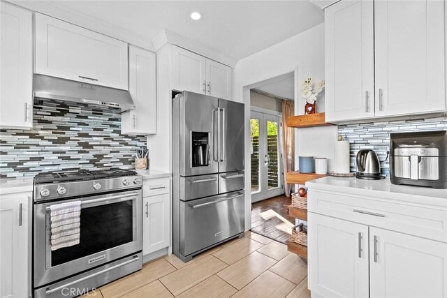 18534 Dylan St, Porter Ranch, CA 91326 - kitchen with stainless steel appliances, exhaust hood, light countertops, white cabinetry, and tasteful backsplash