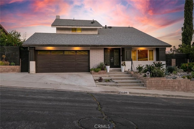 18534 Dylan St, Porter Ranch, CA 91326 - view of front facade with driveway, an attached garage, and brick siding