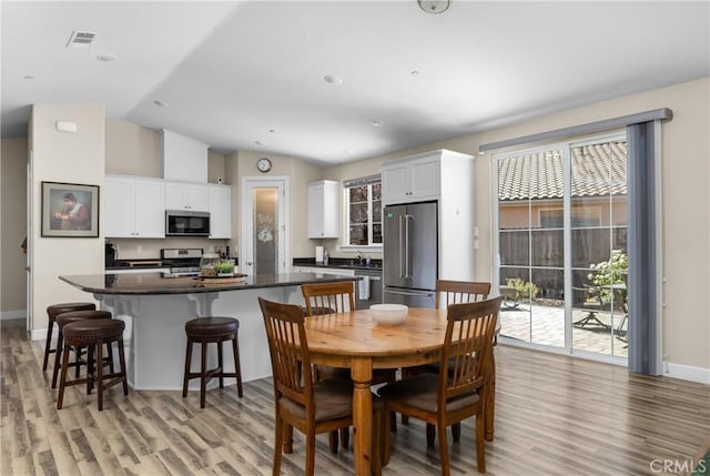 8640 Erika Ct, Atascadero, CA 93422 - dining area with light wood finished floors, lofted ceiling, and baseboards