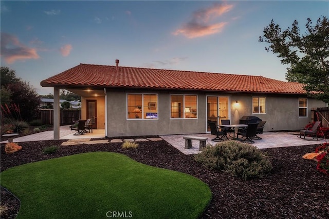 8640 Erika Ct, Atascadero, CA 93422 - back of property at dusk with a patio, a tile roof, and stucco siding