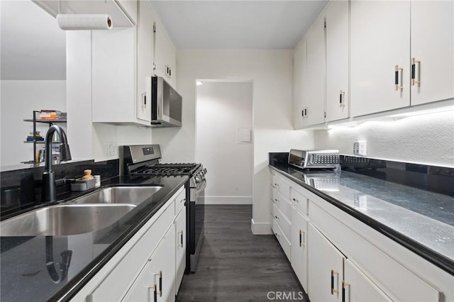 1222 N Olive Dr Unit 409, West Hollywood, CA 90069 - kitchen with stainless steel range with gas cooktop, a sink, dark wood-style flooring, and white cabinetry