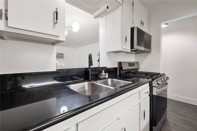1222 N Olive Dr Unit 409, West Hollywood, CA 90069 - kitchen with appliances with stainless steel finishes, white cabinetry, a sink, dark wood-type flooring, and baseboards