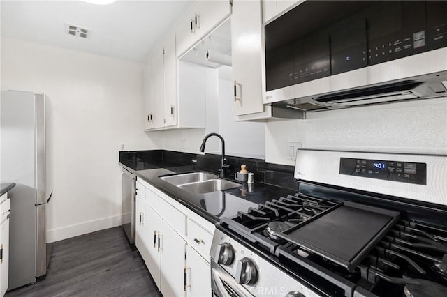 1222 N Olive Dr Unit 409, West Hollywood, CA 90069 - kitchen with stainless steel appliances, a sink, dark countertops, white cabinetry, and baseboards