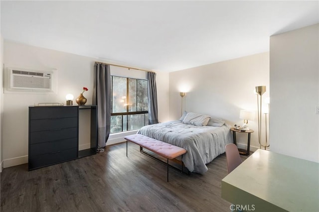 1222 N Olive Dr Unit 409, West Hollywood, CA 90069 - bedroom featuring a wall mounted air conditioner, dark wood finished floors, and baseboards