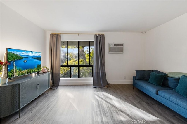 1222 N Olive Dr Unit 409, West Hollywood, CA 90069 - living area with a wall mounted air conditioner, wood finished floors, and baseboards