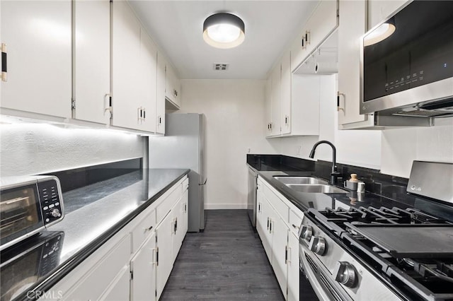 1222 N Olive Dr Unit 409, West Hollywood, CA 90069 - kitchen with appliances with stainless steel finishes, a sink, baseboards, and white cabinetry