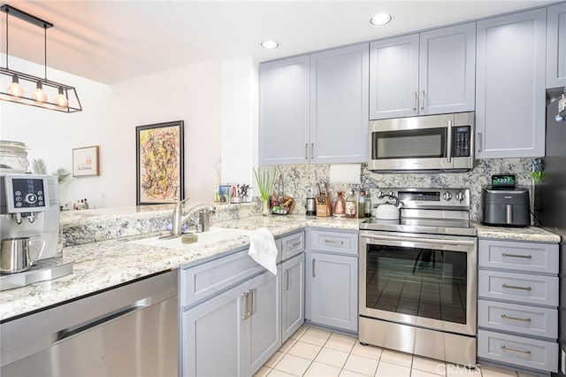 2233 Martin Unit 411, Irvine, CA 92612 - kitchen featuring appliances with stainless steel finishes, gray cabinets, a sink, light tile patterned flooring, and backsplash