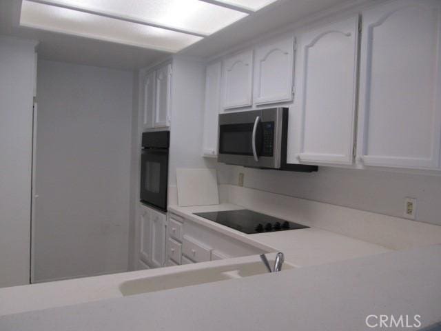 13601 Del Monte Dr Unit M17-46A, Seal Beach, CA 90740 - kitchen featuring black appliances, light countertops, white cabinets, and a sink