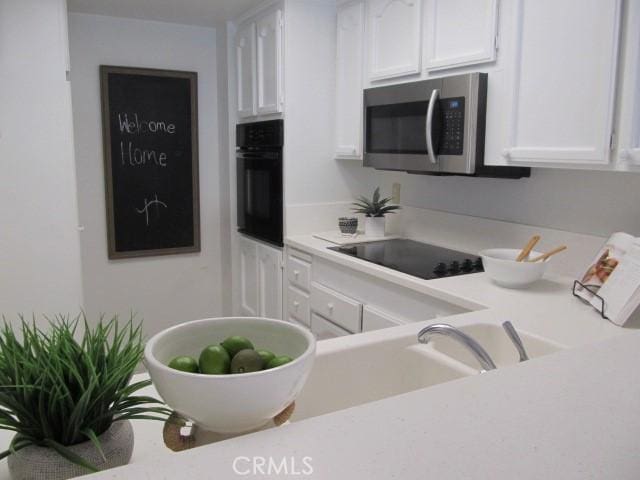 13601 Del Monte Dr Unit M17-46A, Seal Beach, CA 90740 - kitchen featuring black appliances, white cabinets, and light countertops