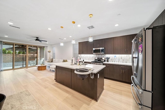 35806 Mccarthy St, Palm Desert, CA 92211 - kitchen featuring stainless steel appliances, light wood-style flooring, light countertops, decorative backsplash, and recessed lighting