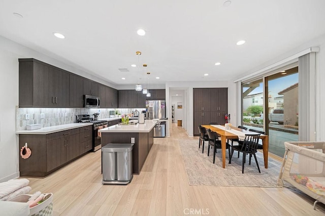 35806 Mccarthy St, Palm Desert, CA 92211 - kitchen with stainless steel appliances, light wood-style floors, dark brown cabinetry, light countertops, and a sink