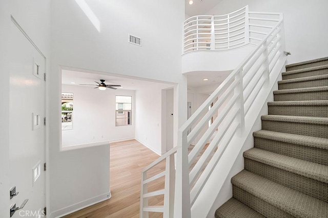 35806 Mccarthy St, Palm Desert, CA 92211 - stairway with wood finished floors, a ceiling fan, a towering ceiling, and baseboards