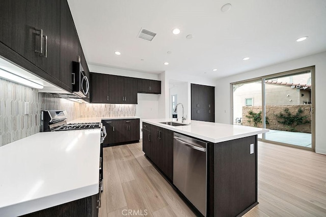 35806 Mccarthy St, Palm Desert, CA 92211 - kitchen featuring stainless steel appliances, a sink, light countertops, backsplash, and light wood-type flooring