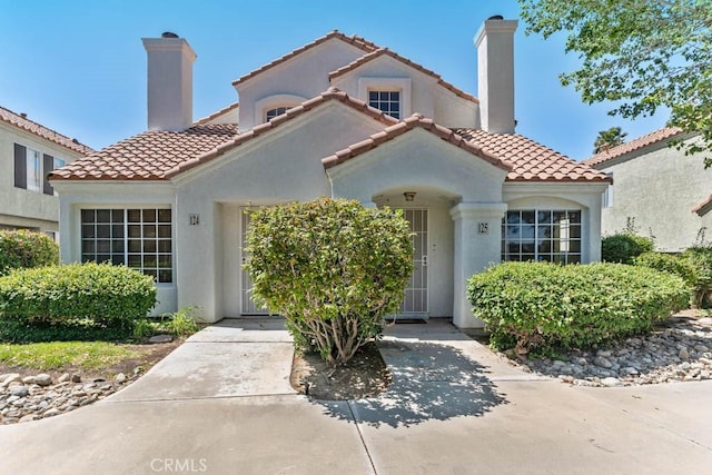 37940 42nd St E Unit 125, Palmdale, CA 93552 - mediterranean / spanish-style house featuring a chimney, stucco siding, and a tiled roof