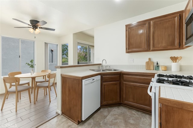 37940 42nd St E Unit 125, Palmdale, CA 93552 - kitchen featuring a sink, white appliances, a peninsula, tile counters, and a ceiling fan