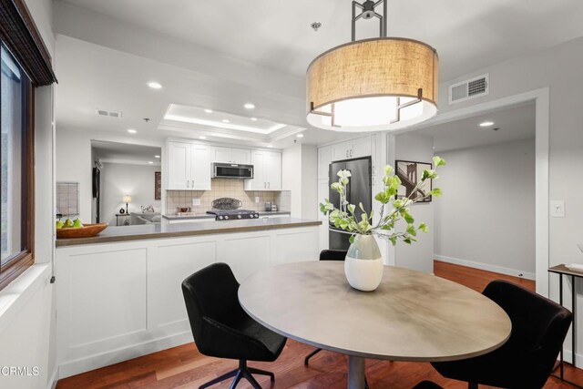 1000 E California Blvd Unit 108, Pasadena, CA 91106 - dining room featuring wood finished floors, a tray ceiling, and recessed lighting