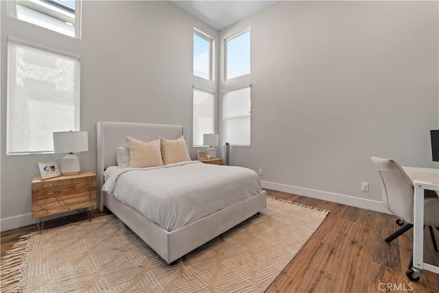 2713 Carnegie Ln Unit B, Redondo Beach, CA 90278 - bedroom featuring baseboards, light wood-style floors, and a high ceiling
