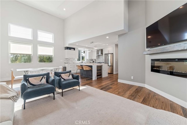 2713 Carnegie Ln Unit B, Redondo Beach, CA 90278 - living room with dark wood-style flooring, baseboards, a high ceiling, a glass covered fireplace, and recessed lighting