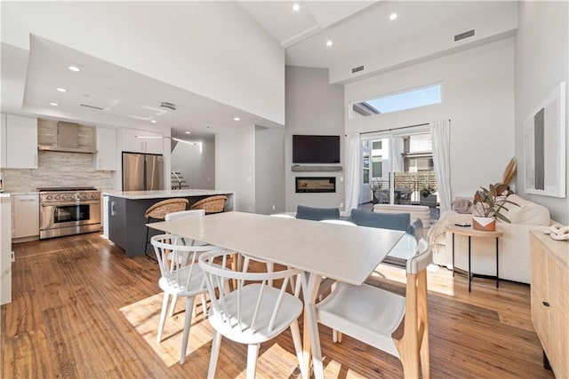 2713 Carnegie Ln Unit B, Redondo Beach, CA 90278 - dining room with a high ceiling, stairway, wood finished floors, recessed lighting, and a fireplace