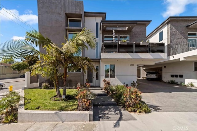 2713 Carnegie Ln Unit B, Redondo Beach, CA 90278 - contemporary house featuring a balcony, driveway, and brick siding