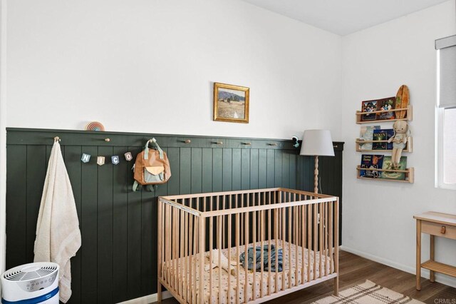 5485 Seacliff Pl Unit 106, San Diego, CA 92154 - bedroom featuring wood finished floors, a crib, and baseboards