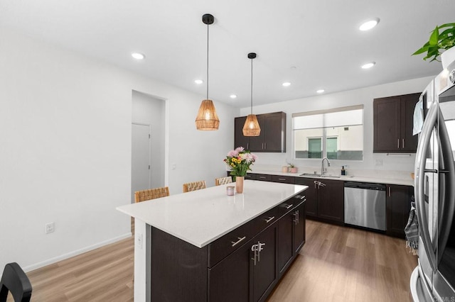 5485 Seacliff Pl Unit 106, San Diego, CA 92154 - kitchen with appliances with stainless steel finishes, light wood-style floors, a sink, light countertops, and dark brown cabinets