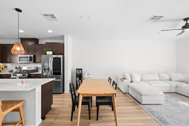 5485 Seacliff Pl Unit 106, San Diego, CA 92154 - kitchen with stainless steel appliances, dark brown cabinets, open floor plan, light wood finished floors, and ceiling fan