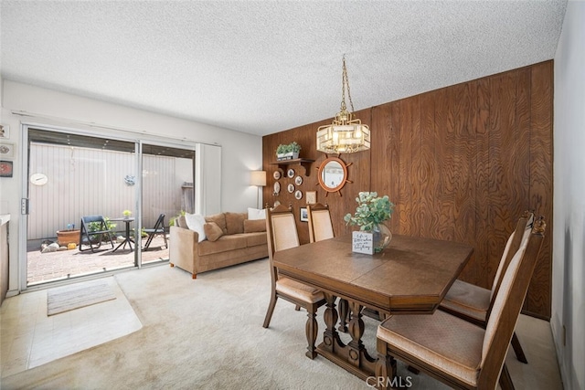 4418 Larwin Ave, Cypress, CA 90630 - dining room featuring wood walls, carpet, a textured ceiling, and a chandelier