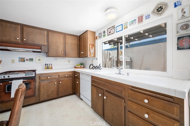 4418 Larwin Ave, Cypress, CA 90630 - kitchen with dishwasher, range with gas stovetop, under cabinet range hood, a sink, and light floors
