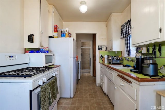 1716 N Fries Ave, Wilmington, CA 90744 - kitchen featuring white appliances, white cabinetry, a sink, and tile counters