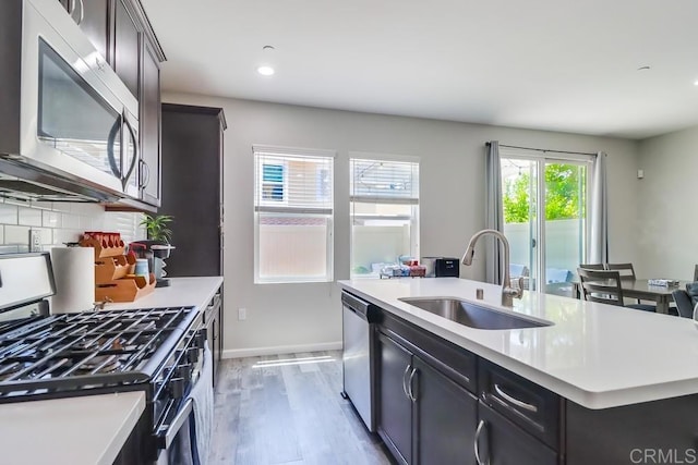 13217 Midnight Star Way, Lakeside, CA 92040 - kitchen with stainless steel appliances, a sink, a kitchen island with sink, light wood-type flooring, and light countertops