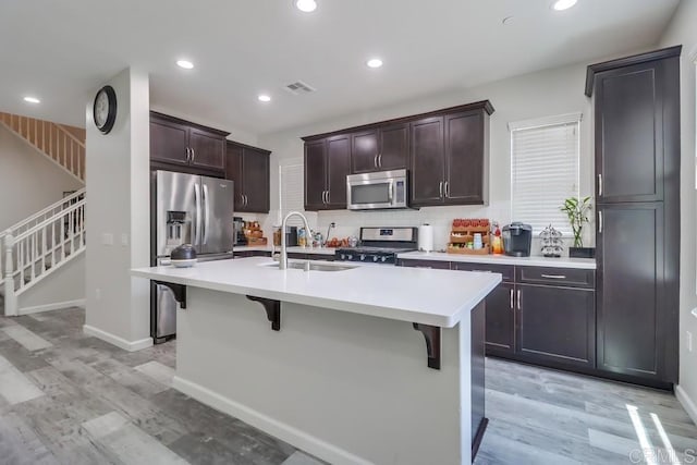 13217 Midnight Star Way, Lakeside, CA 92040 - kitchen featuring appliances with stainless steel finishes, a sink, a breakfast bar area, light wood-style floors, and recessed lighting