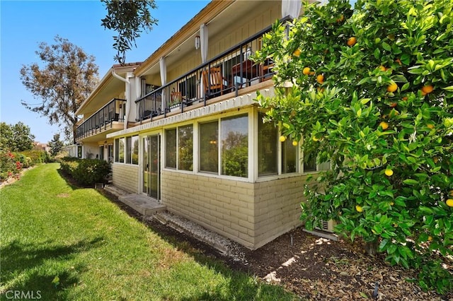 3413 Punta Alta Unit A, Laguna Woods, CA 92637 - view of side of property with a balcony, brick siding, and a lawn